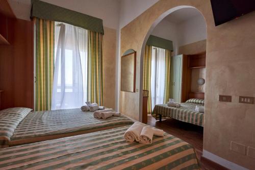 里米尼Hotel Adriatica sul Mare的一间卧室配有两张带毛巾的床