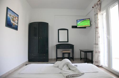 Agios DimitriosΟ Μήλας的卧室配有一张床,墙上配有电视。