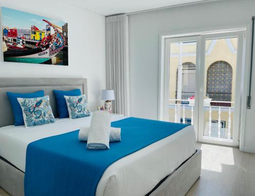 阿威罗Central Tiled Apartment的卧室配有蓝色和白色的床,设有窗户