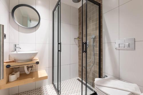 厄吕代尼兹布伦泽酒店的一间带玻璃淋浴和水槽的浴室