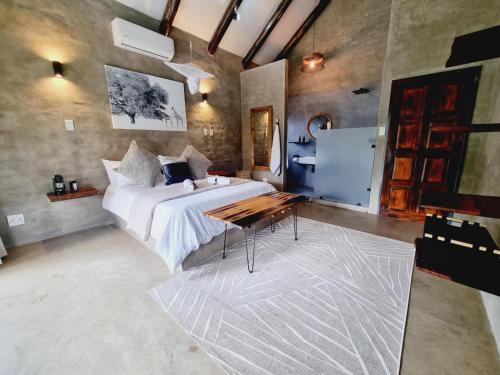 侯斯普瑞特Rhino's Rest Luxury Villa的一间卧室配有一张床和一张桌子