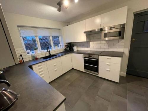 锡德卡普Lovely modern, well-kept house的厨房配有白色橱柜和炉灶烤箱。