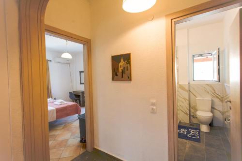 卡西奥皮Kampos Kassiopi Apartment的一间带卫生间的浴室和一间带床的房间
