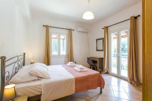 卡西奥皮Kampos Kassiopi Apartment的卧室配有一张床、一张书桌和窗户。