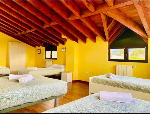 La LosaVilla Arboleda的一间设有四张床的客房,位于拥有黄色墙壁的房间