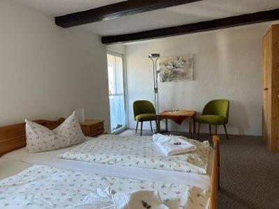 库罗阿尔滕堡海伦尼豪夫酒店的一间卧室配有一张床、两把椅子和一张桌子
