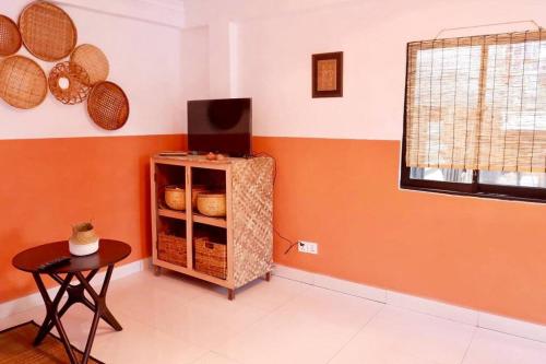 金边Tiny yet Beautiful apartment in the heart of Phnom Penh, Near central market的一间拥有橙色墙壁和篮子架的房间