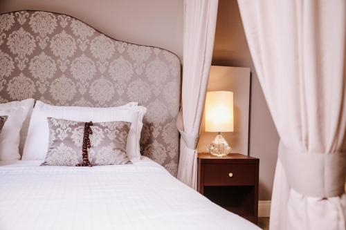 瓦尔多比亚德内Boutique Hotel Municipio 1815的一间卧室配有一张带天蓬的白色床