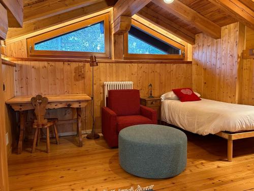 瓦托内切MaisonGorret的小屋内一间卧室配有一张床和一把椅子