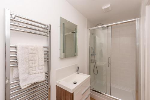 伍拉科姆Seashells的白色的浴室设有水槽和淋浴。