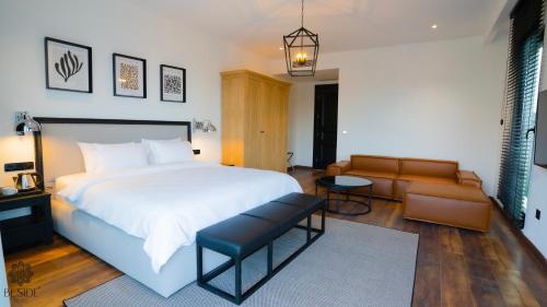 萨姆松Be Side Hotel的卧室配有一张白色的大床和一张沙发。