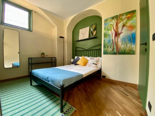 都灵Urban Oasis in the Heart of Turin的卧室配有一张床,墙上挂有绘画作品