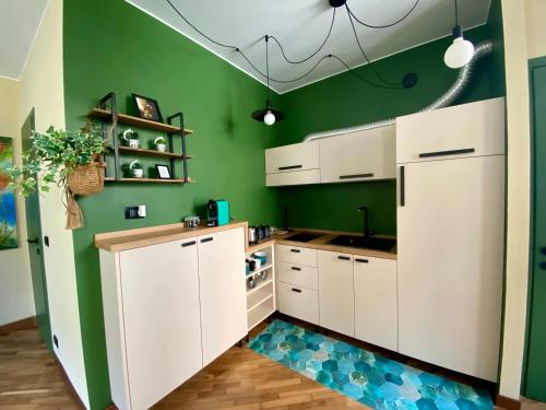 都灵Urban Oasis in the Heart of Turin的厨房配有白色橱柜和绿色墙壁