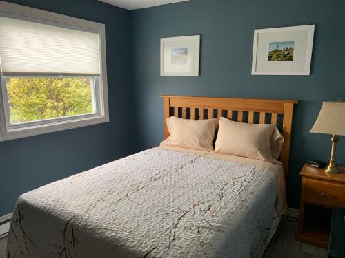 Heartʼs ContentLegges Motel & Restaurant的一间卧室配有一张蓝色墙壁的床和一扇窗户