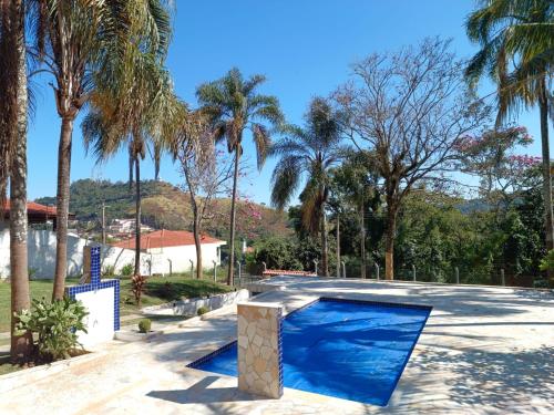 阿瓜斯迪林多亚Chácara Rancho Fundo的一座种植了棕榈树的蓝色游泳池