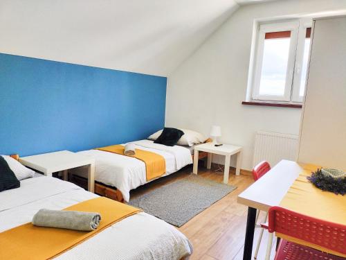 Krajno-ZagórzeAgroturystyka Jodłowa的一间设有三张床和蓝色墙壁的房间