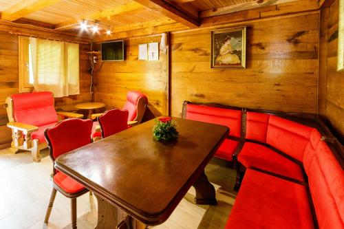 Kokin BrodBrvnara 3 zvezde - brvnara Djordje的一间带桌子和红色椅子的用餐室