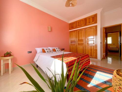 塔姆拉赫特乌兹达尔Monkey's Guest House - Appartement roof top terrasse privée vue sur mer的卧室设有粉红色的墙壁和1张床