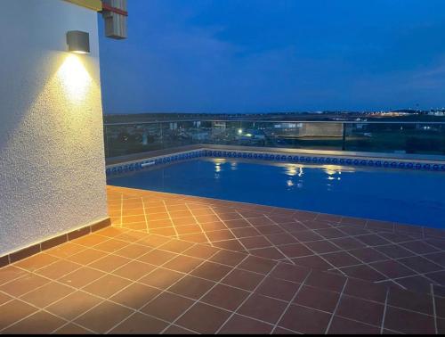 阿克拉Accra Luxury apartments at Oasis Park Residences的夜间在建筑物边的游泳池