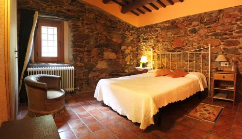 AiguafredaBed and Breakfast Casanova de Sant Miquel的一间卧室设有一张床和石墙
