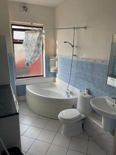 LongfordQuite Broad Resr 1的带浴缸、卫生间和盥洗盆的浴室