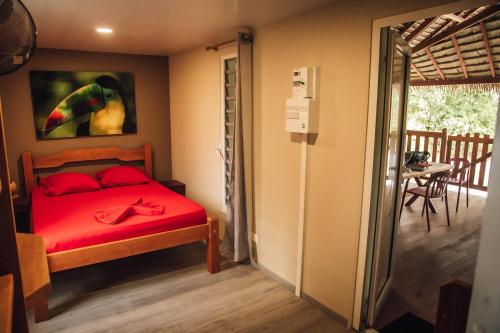 库鲁Palma Lodges的一间卧室配有红色床单和鹦鹉画