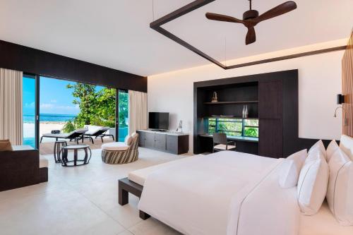 芭环礁The Westin Maldives Miriandhoo Resort的一间卧室设有一张床和一间客厅。