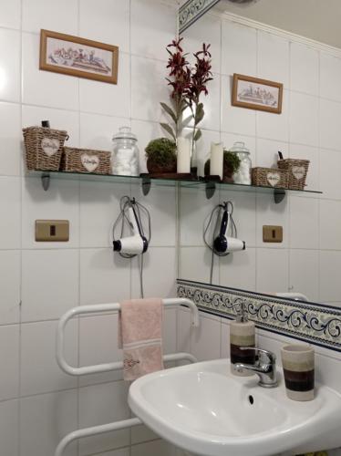 圣地亚哥Dulce hogar的一间带水槽和白色瓷砖墙的浴室