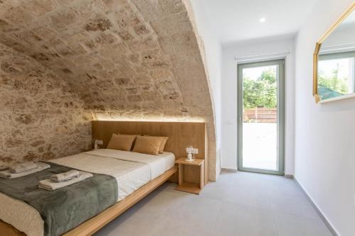 干尼亚Lindas Convent Garden Home 1的一间卧室设有一张带石墙的大床