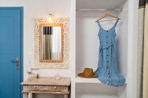 伊奥斯乔拉Cozy little house in Ios的挂在镜子旁墙上的蓝色连衣裙