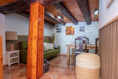 佩德罗－贝尔纳多Casa Rural El Burrito de Gredos的客厅配有桌子和绿色沙发
