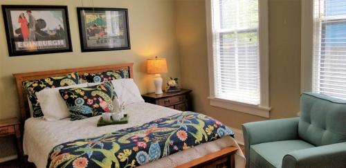 小石城Urban Cottages的一间卧室配有一张床和一张蓝色椅子