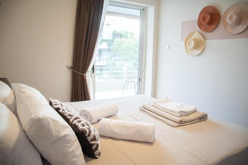瓦尔基扎Naiads Nest - The Cozy Retreat的一间卧室配有带毛巾的床和窗户。