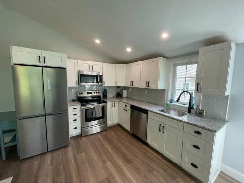 KingstonLil’ Peace & Tranquility的厨房配有白色橱柜和不锈钢用具