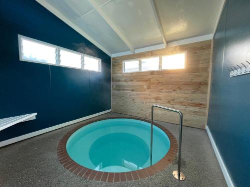 罗托鲁瓦Holdens Bay Holiday Park的蓝色墙壁的房间内的热水浴缸
