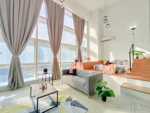八打灵再也Empire City PJ Signature Suites by Manhattan Group的带沙发和大窗户的客厅