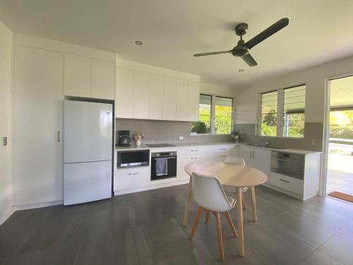 克瓦拉海滩Ranch Retreat的厨房配有桌子和白色冰箱。