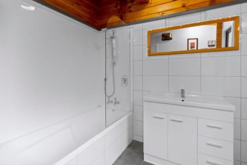 皇后镇Kereru Cottage, Romantic & Beautiful Log Cabin - Queenstown的白色的浴室设有水槽和镜子