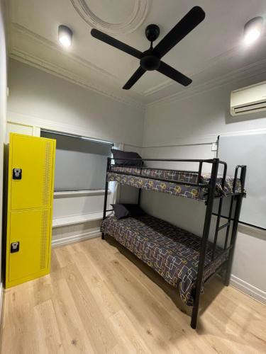 布里斯班Banana Backpackers的客房设有两张双层床和吊扇。