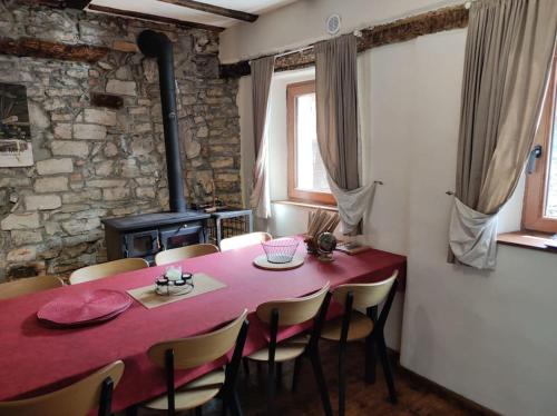 托尔明Casa di Volce - 1801 Stone House的一间用餐室,配有红色的桌子和椅子