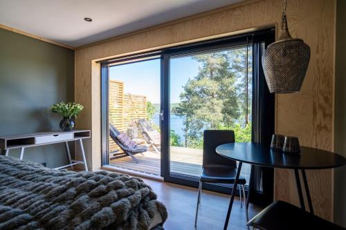 Lekkert gjestehus ved sjøen的一间卧室配有一张床、一张桌子和一个大窗户