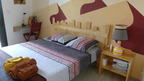 珀蒂蒂勒KAZ à LILO的一间卧室配有一张带木制床头板的床