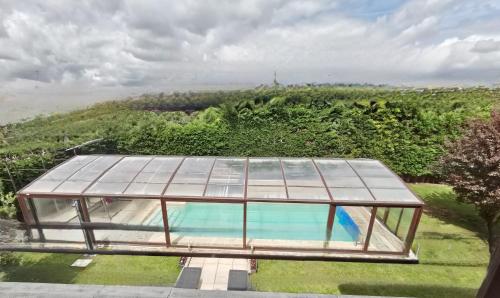 Los TomillaresVILLA TOMILLARES的享有带游泳池的玻璃房子的顶部景色