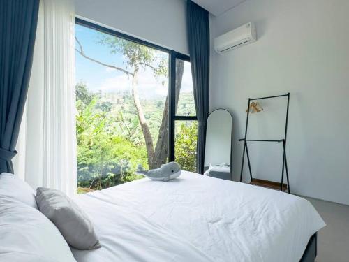 BengkokThalassaville Dago Bandung的卧室配有白色的床和大窗户