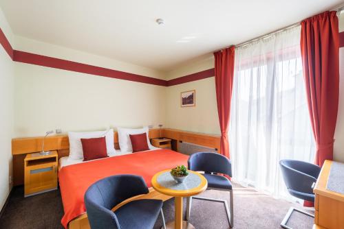 俄斯特拉发Jan Maria Hotel & Restaurant的酒店客房带一张床、一张桌子和椅子