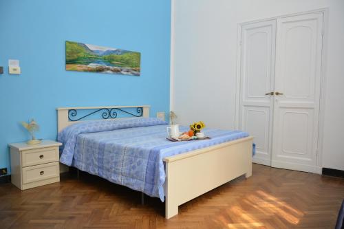 热那亚Family Hotel Balbi的一间卧室设有一张床和蓝色的墙壁