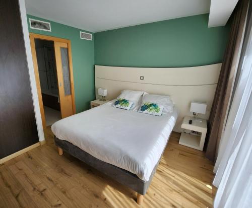 戛纳蒙塔尼温泉酒店的一间卧室配有一张带两个枕头的床