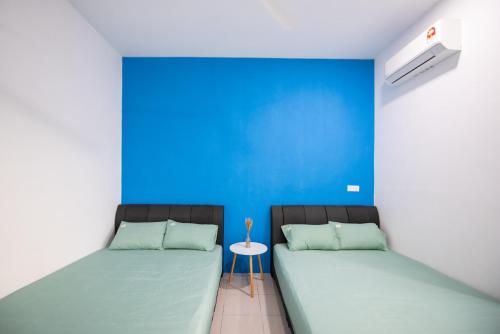 波德申No 19 Studio Homestay (Semi-D), Port Dickson (up to 13 pax)的蓝色墙壁客房的两张床