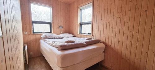 TalknafjordurKirkjubraut - Church street的一张小床,位于带两个窗户的房间