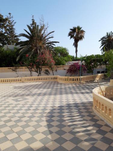 杰尔吉斯Dar El Ferdaous的一个带围栏和棕榈树的瓷砖庭院